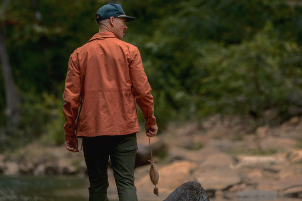 A man is walking down a creek