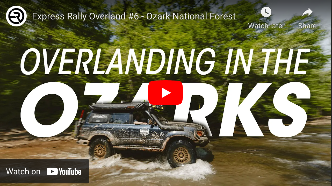 A Toyota Land Cruiser drives through a puddle